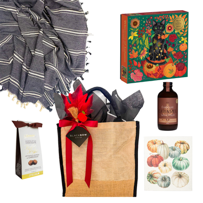 Fall at Home gift basket with cozy throw, fall puzzle, maple drink, chocolates and seasonal kitchen towel