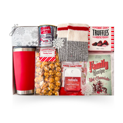A Canadian Christmas gift box with red insulated tumbler, maple syrup, cozy socks, hot chocolate, candy cane popcorn, peppermint truffles and festive treats.