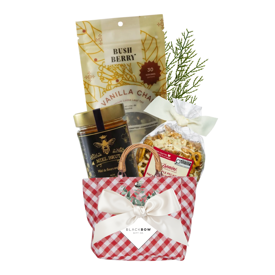 A Sweet Gesture gift featuring vanilla chai tea, gourmet honey and maple pecan crunch in a red gingham tote with ivory bow and Black Bow Gift Co. gift tag.
