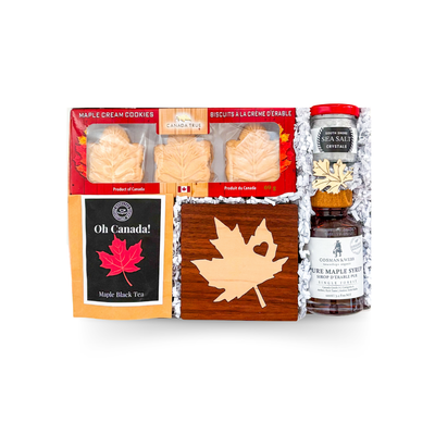 Canadian gift box featuring maple syrup, maple tea, Canadian chocolate, Canadian playing cards, wooden coaster, and Canadian-inspired treats by Black Bow Gift Co.