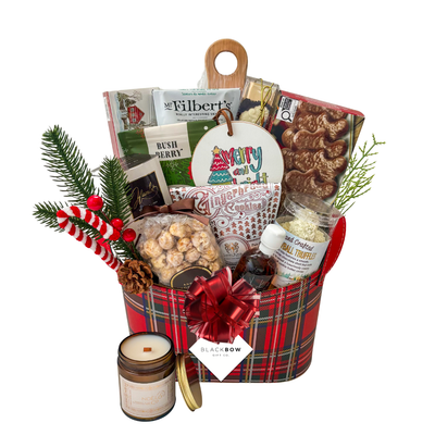A Taste of Christmas gourmet holiday gift basket in a red tartan leatherette keepsake basket with chocolates, savoury snacks, gingerbread treats, festive greenery and optional candle.
