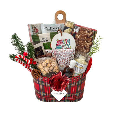A Taste of Christmas gourmet holiday gift basket in a red tartan leatherette keepsake basket with chocolates, savoury snacks, gingerbread treats, festive greenery and optional candle.