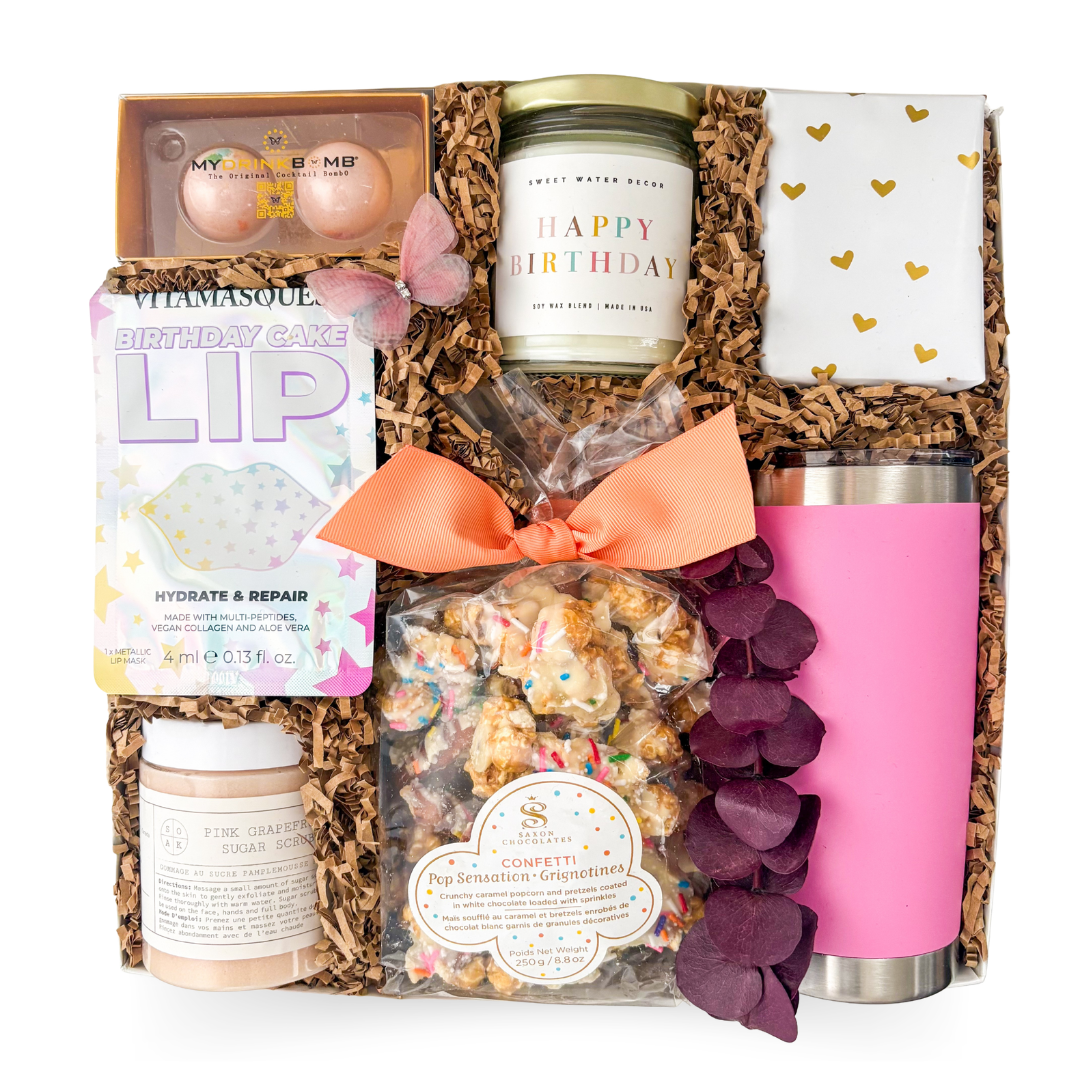 Gift basket with birthday-themed items including a candle, lip balm, and pink tumbler.