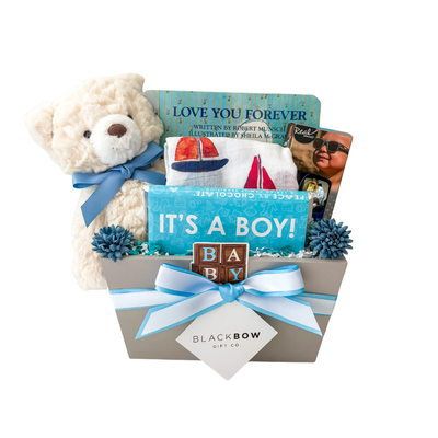 Blue Skies Ahead baby boy gift box with plush teddy bear, Love You Forever board book, sailboat muslin swaddle, baby sunglasses, and premium gift packaging.