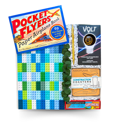 Blueprints & Bright Ideas creative gift box with paper airplane book, rechargeable LED lamp, LEGO-style notebook, magnetic poetry kit, construction coasters, and premium gift packaging.