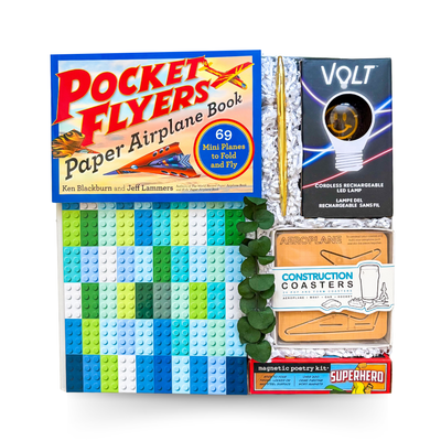 Blueprints & Bright Ideas creative gift box with paper airplane book, rechargeable LED lamp, LEGO-style notebook, magnetic poetry kit, construction coasters, and premium gift packaging.