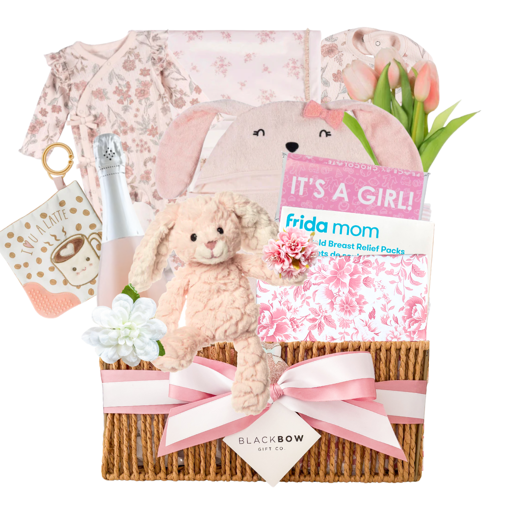Blush Beginnings baby girl gift basket featuring soft pink baby essentials, plush bunny, celebration bottle, keepsake items, and elevated baby gifting by Black Bow Gift Co.
