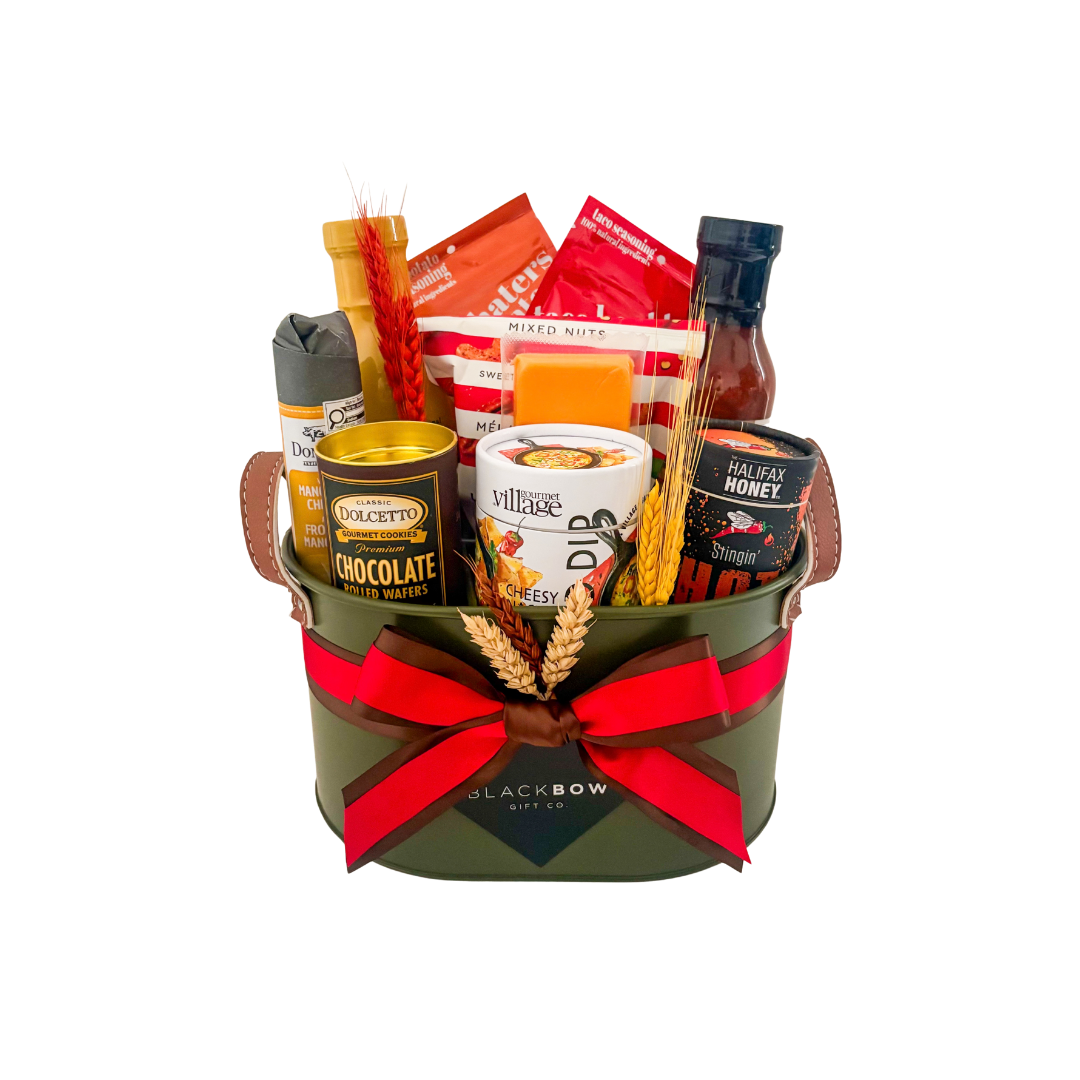 Bold Bites gourmet BBQ gift basket in an army green metal caddy with Joe Beef sauces, gourmet seasonings, cheese, nuts and chocolate treats.
