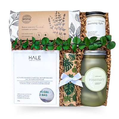 Luxury botanical wellness gift box with rosemary planter kit, purifying charcoal bag, soy candle, lavender infused eye rest, and gourmet chocolates in earthy tones