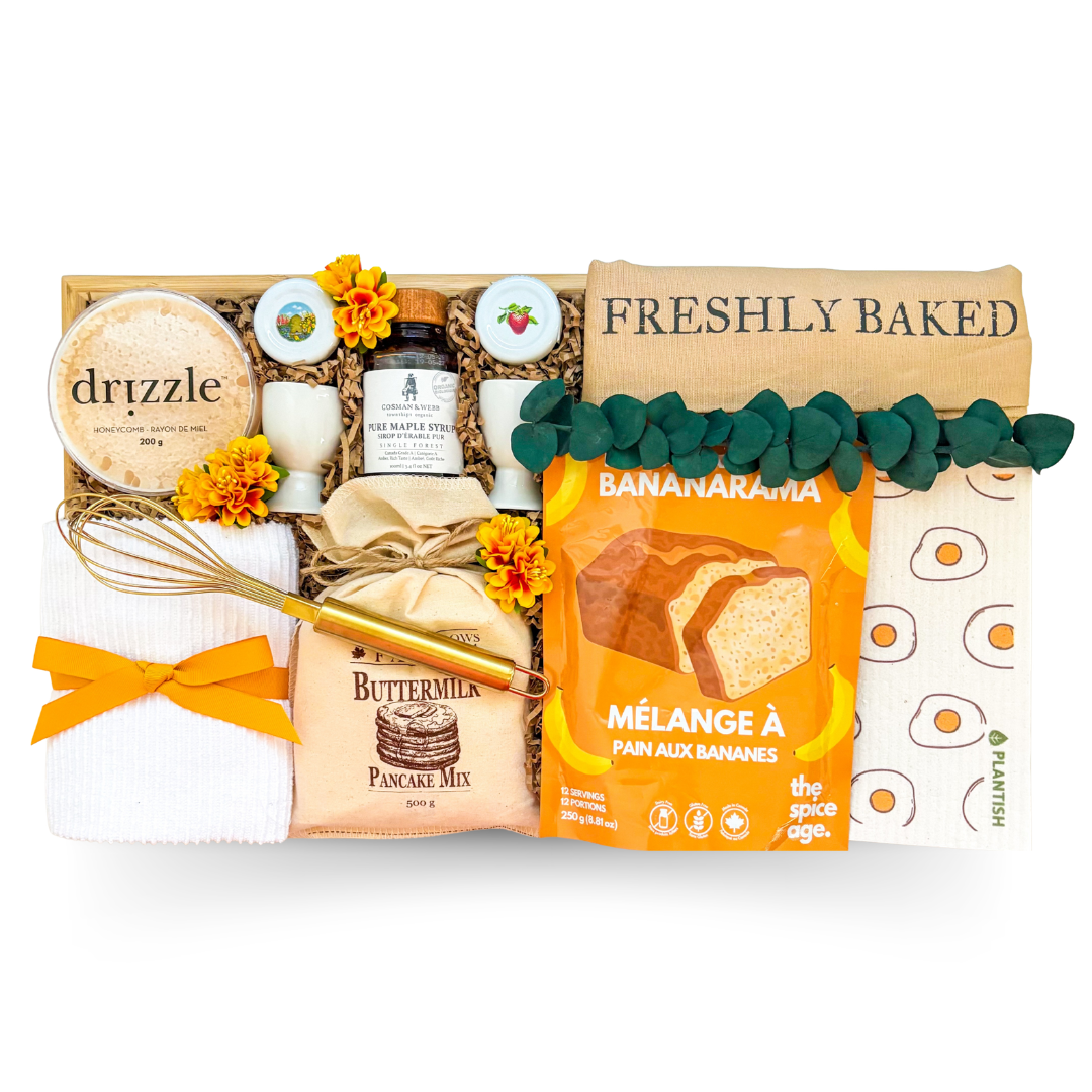 Breakfast in Bed gift basket presented on a bamboo bed tray with pancake mix, banana bread mix, pure maple syrup, honeycomb, egg cups, tea towel, whisk, and breakfast accessories.

