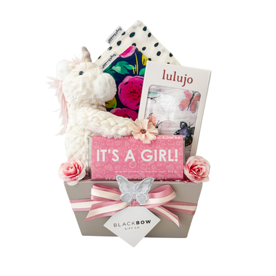 Butterfly Wishes baby girl gift basket with plush unicorn, butterfly muslin swaddle, floral baby bibs, It's a Girl chocolate, and premium gift packaging.