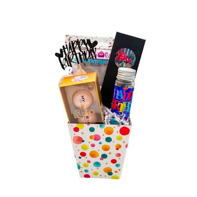 Birthday gift basket with cake treats, drink bombs, puzzle, and celebratory details, packaged in a colourful celebration paper basket.