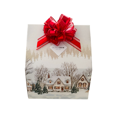 The Winter Escape luxury gift featuring a cozy blanket, elegant drinkware, gourmet chocolates, hot chocolate and artisan treats in a beautifully illustrated winter village gift package.