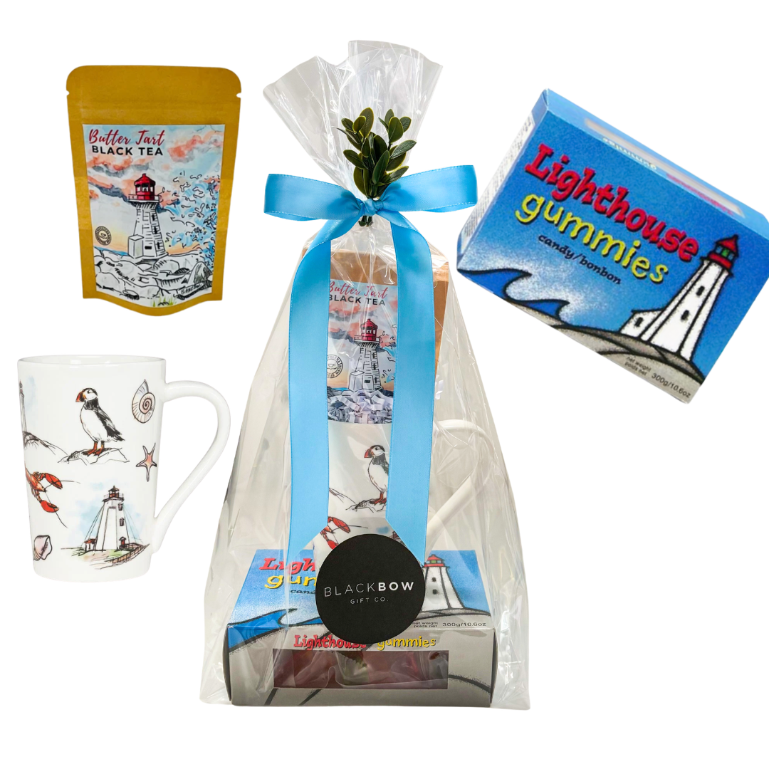 Coastal-themed gift featuring a lighthouse mug, East Coast tea, and lighthouse gummies presented in cello wrap with ribbon and decorative accents by Black Bow Gift Co.
