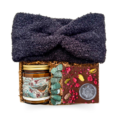 Thoughtful gift featuring a wool headband, Winter Melody candle, and chocolate bar styled for cozy, refined comfort.