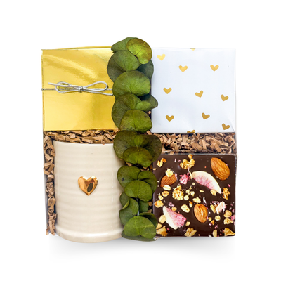 Luxury coffee and tea gift box featuring a keepsake heart mug, handcrafted chocolate, gourmet treats, and a choice of premium tea, hot chocolate, or vanilla latte, beautifully presented in a luxury small gift box.