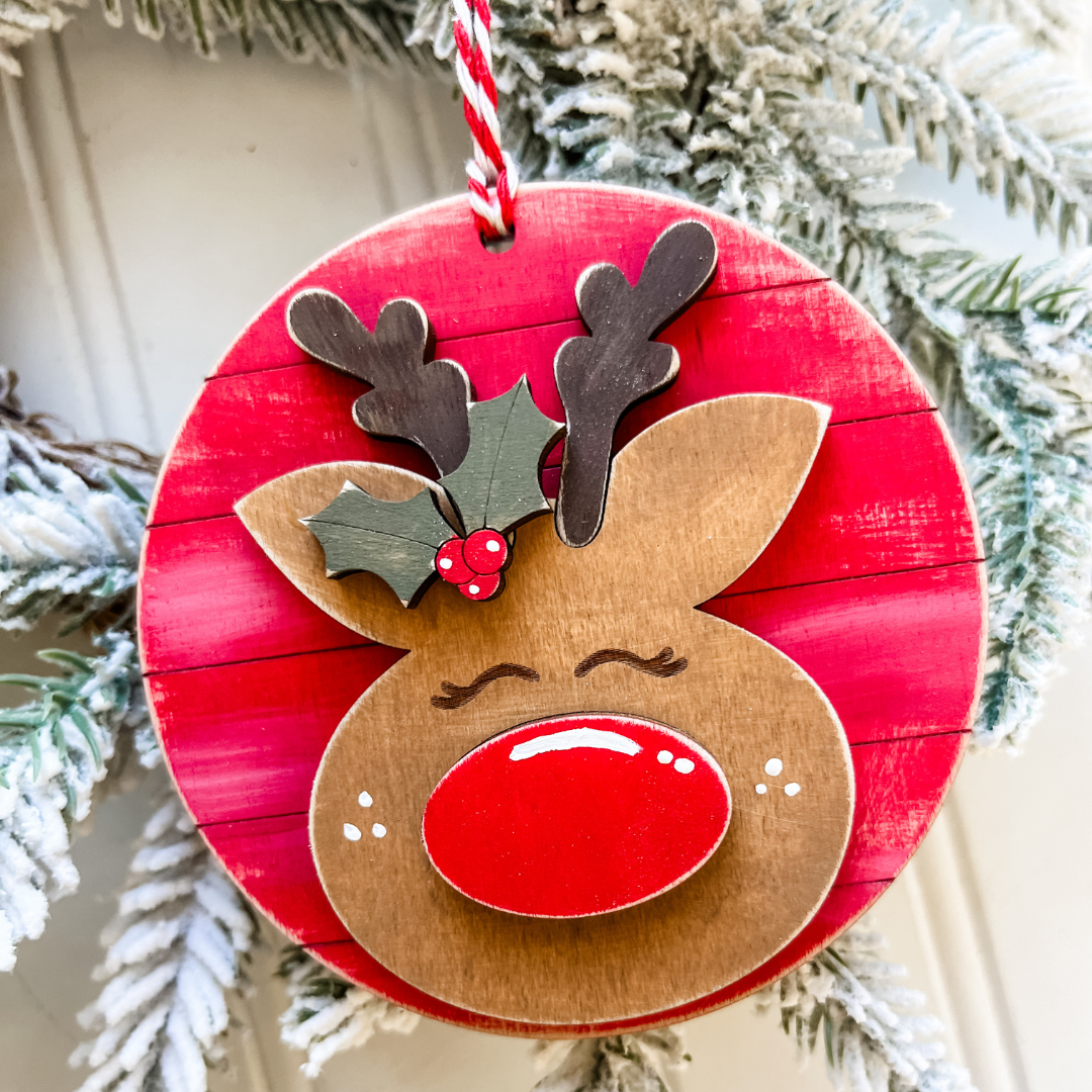 DIY reindeer ornament kit with wooden reindeer pieces and festive craft supplies for creating a personalized Christmas tree decoration