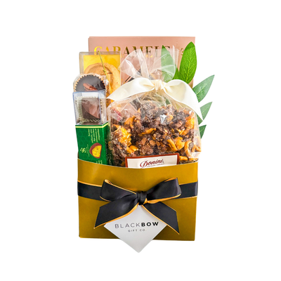 Gourmet sweet treat gift basket with chocolates, popcorn, caramels, cookies, and nut cups, styled in a premium paper basket.