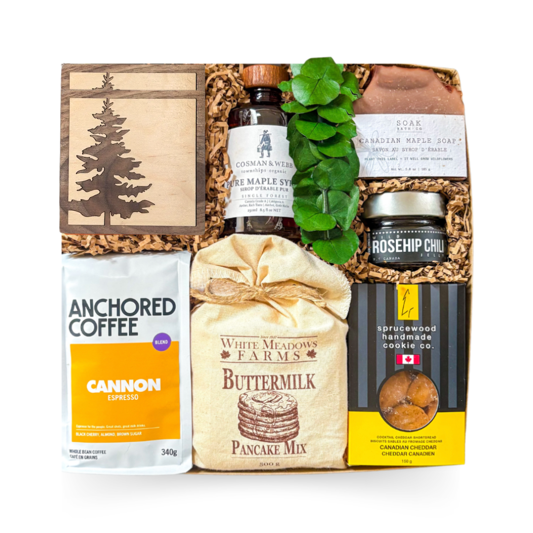Canadian gourmet gift box featuring artisan coffee, pancake mix, pure Canadian maple syrup, handcrafted cookies, small-batch preserves, maple soap, engraved wood coaster, and premium Canadian-inspired treats and keepsakes.
