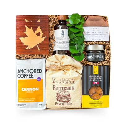 Canadian gourmet gift box featuring artisan coffee, pancake mix, pure Canadian maple syrup, handcrafted cookies, small-batch preserves, maple soap, engraved wood coaster, and premium Canadian-inspired treats and keepsakes.