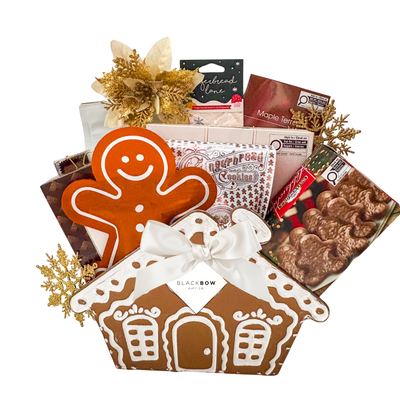 Gingerbread Wishes Christmas gift basket featuring festive chocolates, gingerbread treats, a decorative gingerbread house keepsake ornament and elegant gold holiday accents.