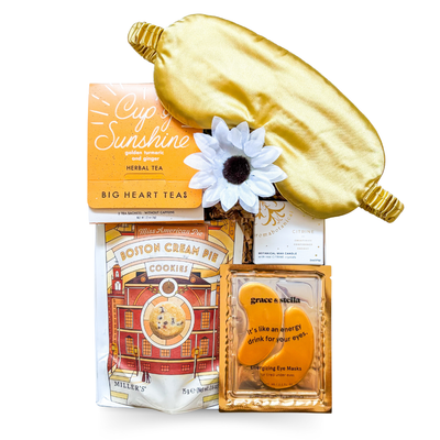 Golden Hour Gift Box with gold satin eye mask, citrine candle, tea, and cookies styled in white and gold for a soothing, radiant presentation.