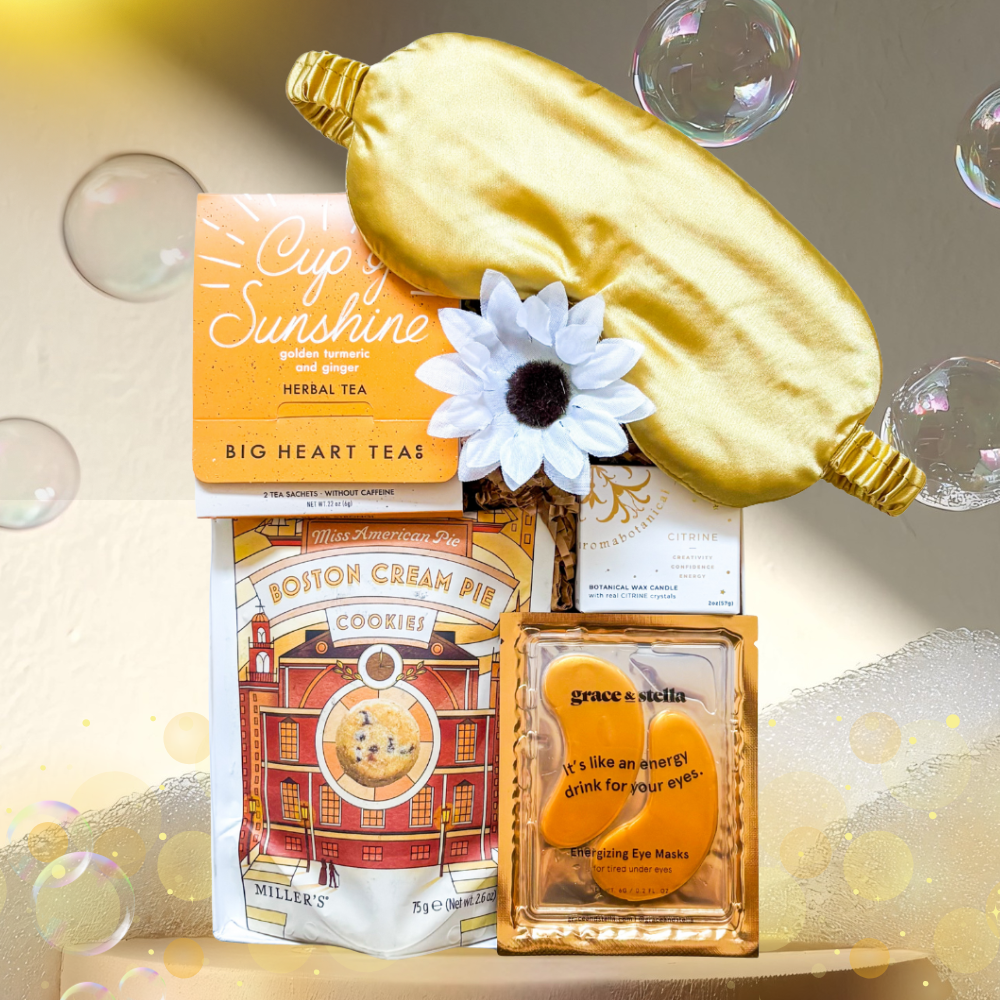 Golden Hour Gift Box with gold satin eye mask, citrine candle, tea, and cookies styled in white and gold for a soothing, radiant presentation.
