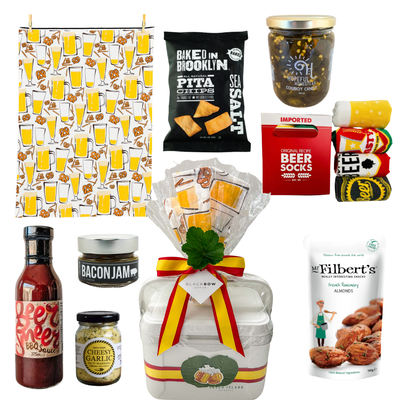 BBQ cooler gift featuring gourmet snacks, beer-themed tea towel, barbecue sauce, savory treats, and reusable cooler presentation by Black Bow Gift Co.