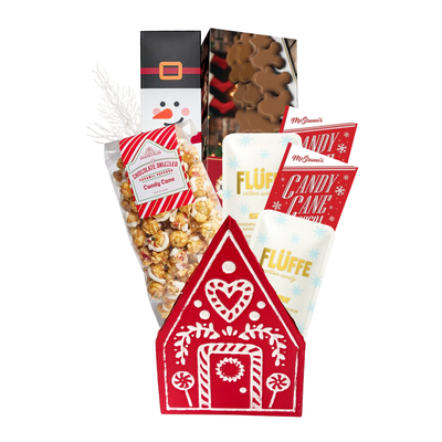 Holiday Happiness Christmas gift basket featuring a red gingerbread house keepsake filled with festive chocolates, cookies, candy cane popcorn and holiday treats.