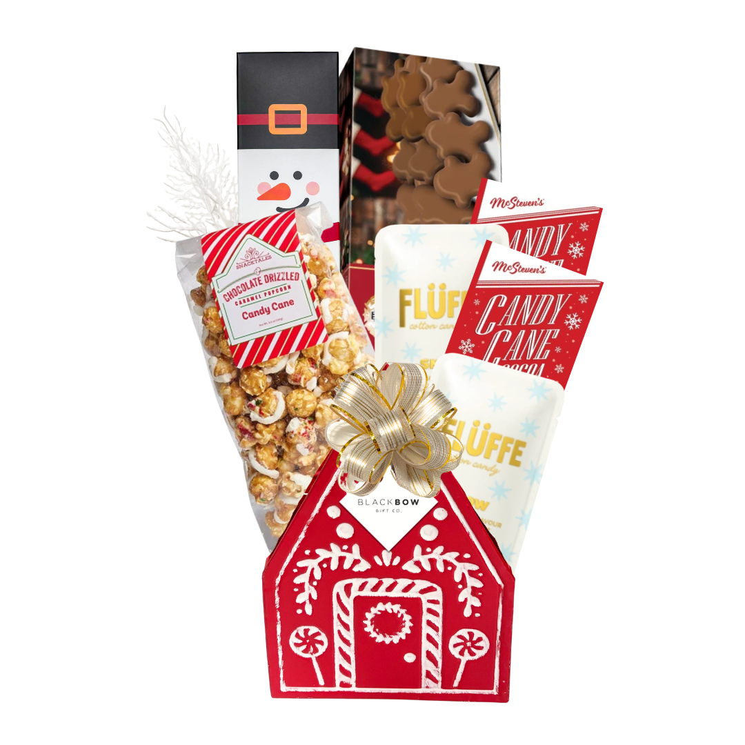 Holiday Happiness Christmas gift basket featuring a red gingerbread house keepsake filled with festive chocolates, cookies, candy cane popcorn and holiday treats.