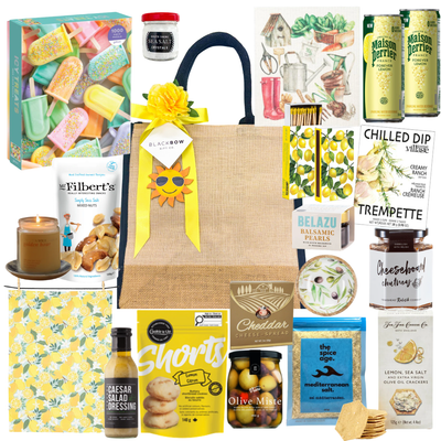 Lemon & Leisure summer gift tote with lemon-themed treats, Mediterranean snacks, crackers, olives, dips, sparkling beverages, and optional puzzle add-on for family gifting.