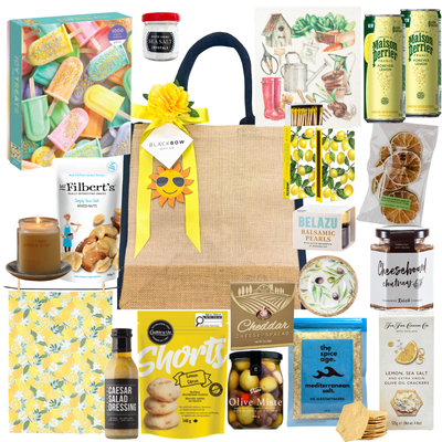Lemon & Leisure summer gift tote with lemon-themed treats, Mediterranean snacks, crackers, olives, dips, sparkling beverages, and optional puzzle add-on for family gifting.