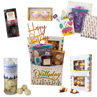 Birthday gift basket with cake, chocolates, truffles, and festive birthday treats, packaged in a happy birthday paper basket.