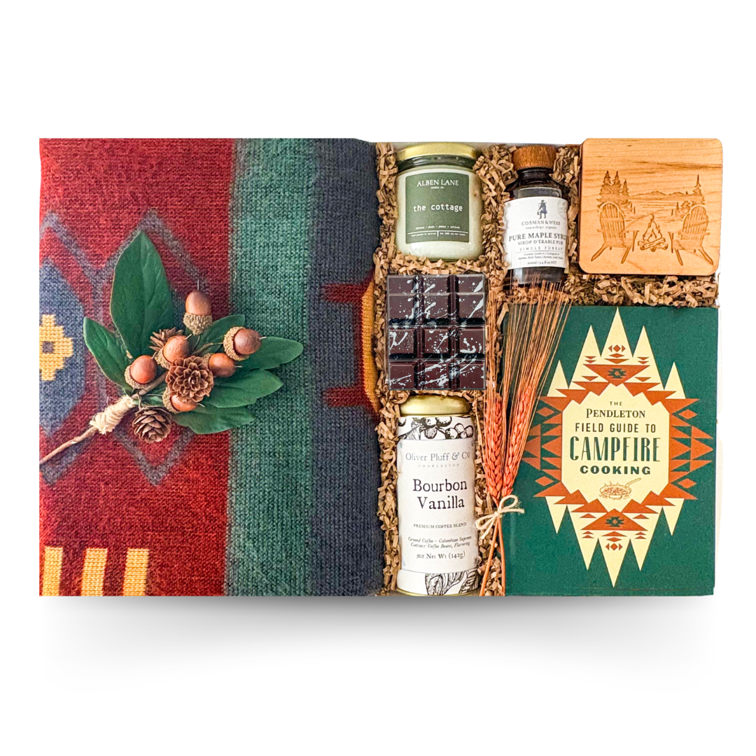Campfire-inspired luxury gift box featuring gourmet comforts, maple accents, cozy textures, and relaxing essentials presented in an XL keepsake box with candle options designed for cozy weekends, cottage getaways, and meaningful moments of unwinding.