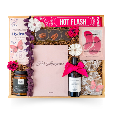 Pink-toned menopause survival gift in a wood box with comforting and playful feminine accents.