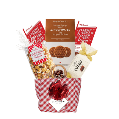 Candy Cane Wishes Christmas gift basket in a red gingham keepsake basket with candy cane treats, hot chocolate, caramel popcorn, chocolates and festive accents.