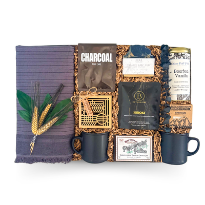 XL luxury keepsake gift box featuring a woven throw blanket, premium coffee, mugs, bath soak, shower steamers, artisan soap, charcoal face mask, peppermint bark, and spa-inspired self-care essentials.