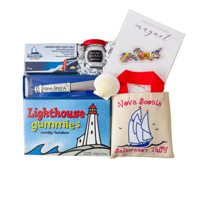 Nova Scotia themed gift box featuring local treats, sea salt, lighthouse gummies, a Nova Scotia spreader, shortbread cookies and a choice of keepsake patch or pressed flower magnet by Black Bow Gift Co.