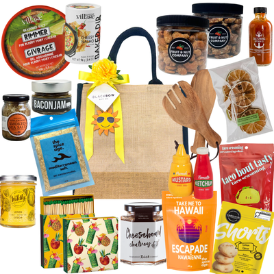 Patio Pantry gourmet summer gift tote with snacks, Caesar mix essentials, dips, seasonings, entertaining accessories, and savoury treats in a burlap tote.