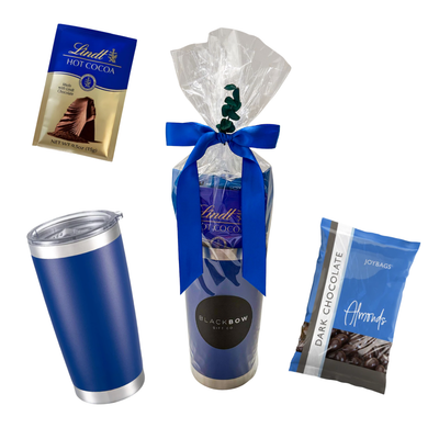 Blue tumbler gift featuring hot chocolate, sweet treats, and snack favourites presented in cello wrap with ribbon and decorative accents by Black Bow Gift Co.