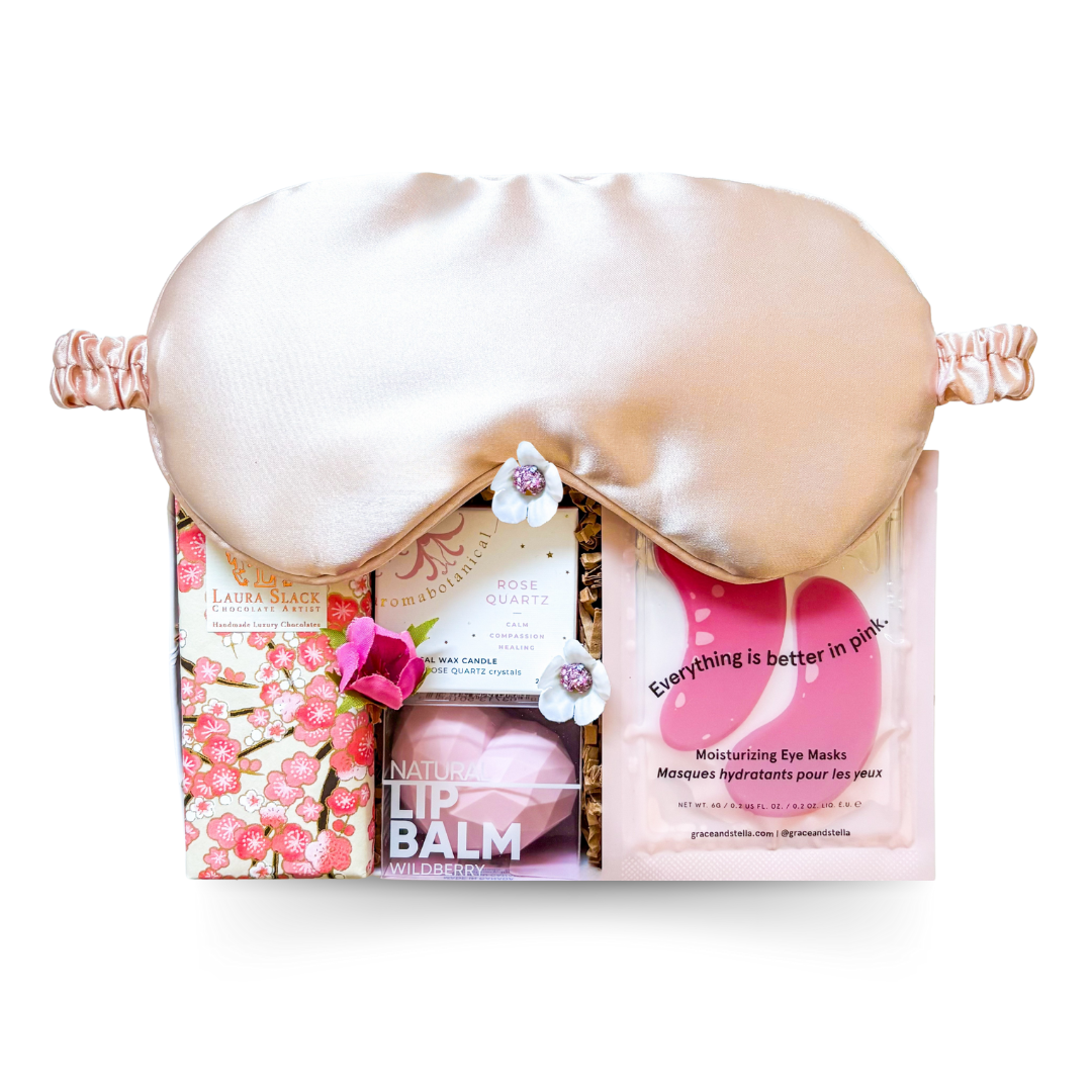Pink Dreams Gift Box with amethyst candle, pink eye mask, under-eye patches, and hand-painted chocolate bar styled in soft pink tones.