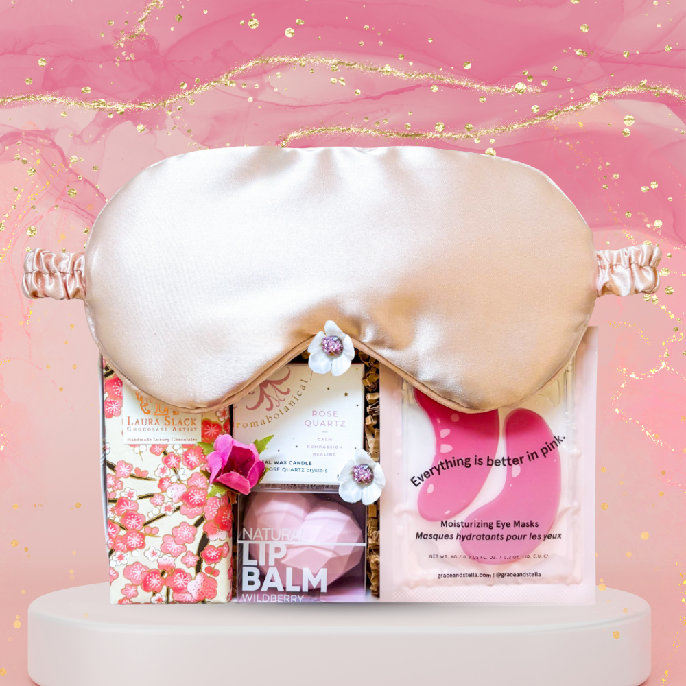 Pink Dreams Gift Box with amethyst candle, pink eye mask, under-eye patches, and hand-painted chocolate bar styled in soft pink tones.