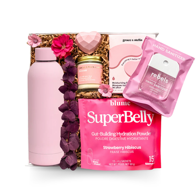 Luxury keepsake wellness gift box featuring a pink insulated bottle, hydrating eye masks, botanical candle, hydration powder, heart-shaped bath bomb, and premium self-care essentials in pink tones.