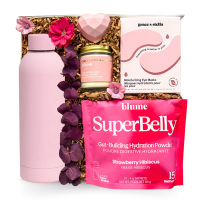 Luxury keepsake wellness gift box featuring a pink insulated bottle, hydrating eye masks, botanical candle, hydration powder, heart-shaped bath bomb, and premium self-care essentials in pink tones.