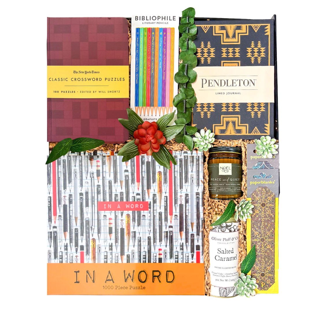 Luxury oversized high-gloss black magnetic gift box featuring optional books, crossword puzzle book, 1,000-piece puzzle, Pendleton journal, coloured pencils, insulated tumbler, gourmet coffee, artisan chocolates, candle, bookmark, and gifts for book lovers arranged in a layered presentation.

