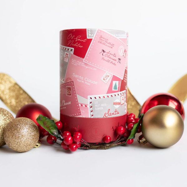 Santa’s Cookies luxury loose herbal tea in a festive red holiday tin featuring Santa Claus and Christmas postcard-inspired artwork, surrounded by ornaments and seasonal greenery.