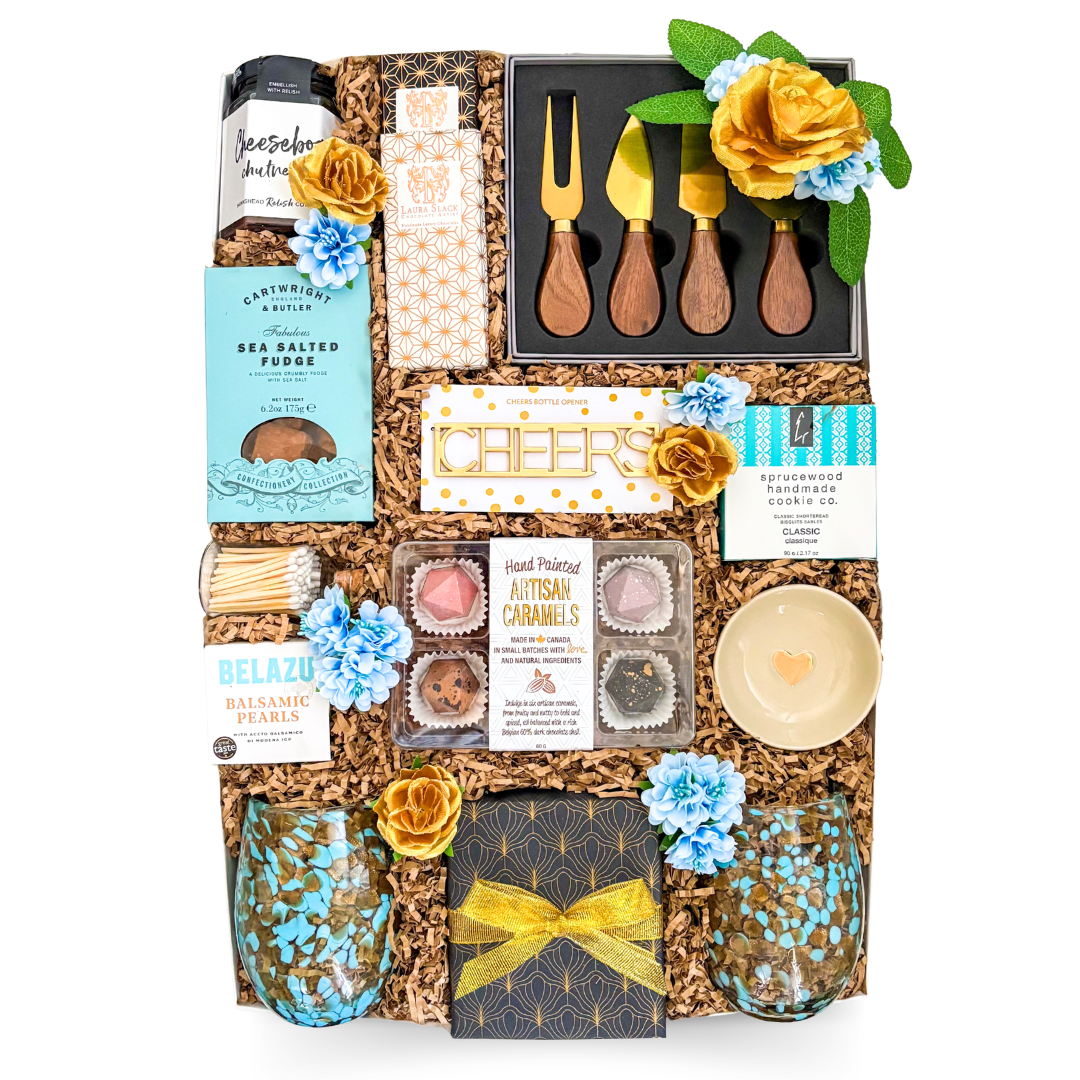 Luxury gourmet gift box featuring artisan treats, charcuterie accessories, serving pieces, decorative glassware, candle, and entertaining essentials by Black Bow Gift Co.