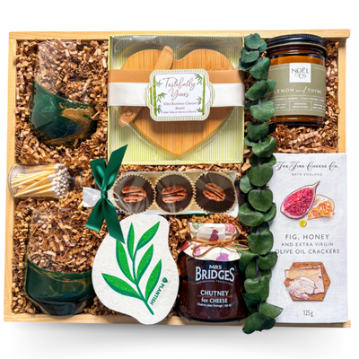 Indulgent wine and cheese gift with heart-shaped board and wine glasses styled for shared moments.
