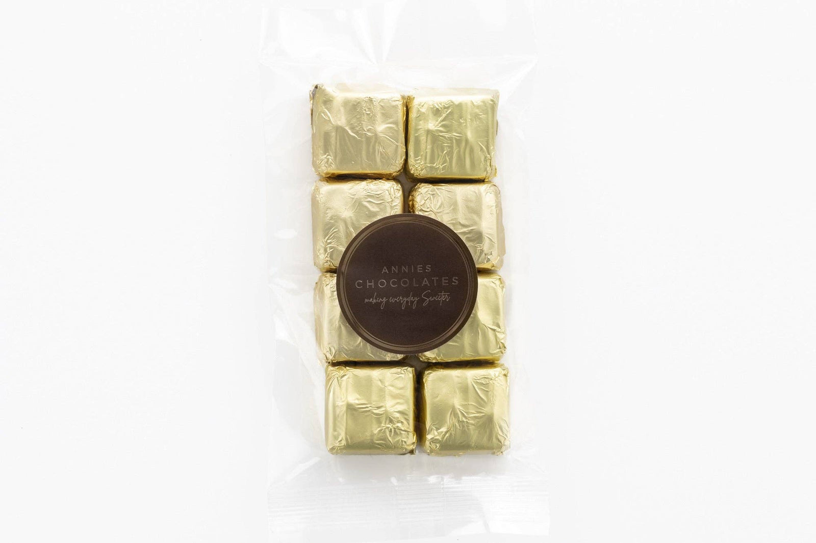 Annie’s Chocolates signature butter rum flavoured milk chocolates in gold foil wrapping, secured in a clear plastic pouch.