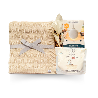 Soft Beginnings luxury baby gift with cream blanket, white onesie, sound machine, and gentle bath items